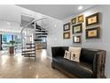 Living room with a black leather couch and a spiral staircase leading to the second floor at 201 W Laurel St # 1006, Tampa, FL 33602