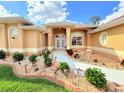 Close up view of the front entrance with colorful landscaped beds at 2329 Como St, Port Charlotte, FL 33948
