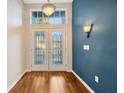Bright foyer showcasing hardwood flooring, a stylish light fixture, and a charming, colored accent wall at 3339 Brenford Pl, Land O Lakes, FL 34638