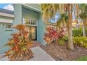 Inviting front entrance with decorative glass doors, lush tropical plants, and a secure entry system at 3339 Brenford Pl, Land O Lakes, FL 34638