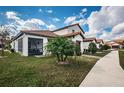 View of the home's rear exterior, screened in porch, lush lawn and mature landscaping at 5316 Stoic Vale Dr, Wimauma, FL 33598