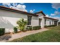 Well-kept single-story home with a terracotta roof, manicured lawn, and a paved walkway to the entrance at 5316 Stoic Vale Dr, Wimauma, FL 33598
