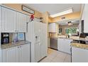 Well-lit kitchen with white cabinets, granite counters, and stainless steel appliances at 6109 Mirada Cir, St Petersburg, FL 33715