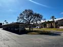 Community carport area with mature shade trees and additional parking, near beautifully maintained townhomes at 7040 Cognac Dr # 1, New Port Richey, FL 34653