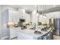 Modern kitchen featuring stainless steel appliances, an island with seating, and pendant lighting at 8100 Moonbeam Ave, Sarasota, FL 34241