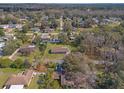 An aerial view shows homes in a wooded neighborhood with mature trees and lush surroundings at 10171 Patrick St, Brooksville, FL 34601