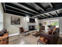 Open living room featuring a fireplace, hardwood floors, leather furniture, and a beamed ceiling at 11935 Riverhills Dr, Temple Terrace, FL 33617