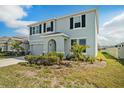 Charming two-story home with a well-maintained lawn, attached garage, and inviting front entryway at 16631 Mooner Plank Cir Cir, Wimauma, FL 33598