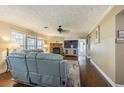 Living room with hardwood floors, a stone fireplace, and natural light from the multiple windows at 17480 Nuthatch Rd, Weeki Wachee, FL 34614