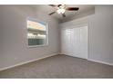 Neutral bedroom offers a ceiling fan, window and closet with double doors at 1814 Wood Trail St, Tarpon Springs, FL 34689