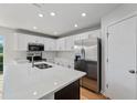 Modern kitchen with white cabinets, stainless steel appliances, and a center island at 2032 Sunset Meadow Dr, Clearwater, FL 33763