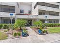 Exterior view of building entrance with well maintained landscaping and visible handicap access at 2583 Countryside Blvd # 3212, Clearwater, FL 33761