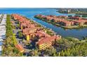 Stunning aerial view showcases waterfront condos with boat docks, surrounded by mature trees and blue skies at 2717 Via Cipriani # 620A, Clearwater, FL 33764