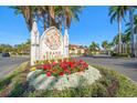 Grand Bellagio community sign surrounded by landscaping including red and white flowers at 2717 Via Cipriani # 623B, Clearwater, FL 33764