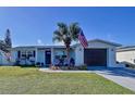 Beautiful home with green grass, palm tree with the American flag, and small rocking chairs at 3142 Domino Dr, Holiday, FL 34691