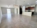 Spacious open-concept living and dining area with tile floors and views into kitchen at 3406 Kearsney Abbey Cir, Dover, FL 33527