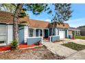 Inviting blue home with a well-kept front yard, mature landscaping, and a charming entrance pathway at 3544 Landale Dr, Holiday, FL 34691