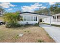 Well-maintained house with mature landscaping and a driveway on a sunny day at 5125 Jo St, Zephyrhills, FL 33542