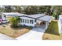 Beautifully landscaped single-story home with metal roof and covered carport at 5125 Jo St, Zephyrhills, FL 33542