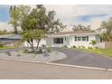 Inviting home boasting a circular driveway, palm trees and attractive landscaping at 6655 Colony S Dr, St Petersburg, FL 33705