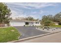 Beautiful home featuring a circular driveway, mature trees, and elegant landscaping at 6655 Colony S Dr, St Petersburg, FL 33705