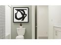 Well-lit bathroom with a subway tiled shower and a modern, decorative art print at 8508 Bella Mar Trl, Parrish, FL 34219