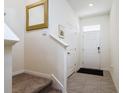 Bright entryway features neutral walls, decorative mirror, tile flooring, and carpeted stairs at 9258 Rock Harbour Way, Tampa, FL 33637