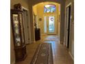 Inviting foyer with tile flooring, decorated glass door and transom window allowing for ample natural light at 116 Silver Falls Dr, Apollo Beach, FL 33572