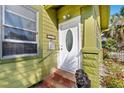 Exterior shot of front door with white trim and a decorative oval window, and steps at 123 17Th Se Ave, St Petersburg, FL 33701