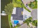 Aerial view of renovated home and pool on waterfront property with dock and lush tropical landscaping at 1514 Sea Gull S Dr, St Petersburg, FL 33707