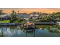 Waterfront home with a boat lift and a two-story home with balconies, at sunset at 1930 Kansas Ne Ave, St Petersburg, FL 33703