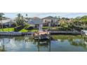 Waterfront property with boat dock, seawall, lawn, and a two-story home with balconies at 1930 Kansas Ne Ave, St Petersburg, FL 33703