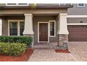 Inviting front porch with stone accents and a stylish front door, enhancing curb appeal at 19429 Paddock View Dr, Tampa, FL 33647