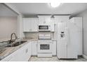 Well-lit kitchen featuring updated white appliances and a modern countertop at 2914 Westmoreland Ct, New Port Richey, FL 34655