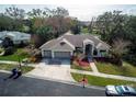 Aerial view of a single-story home with a three-car garage, manicured lawn, and mature trees at 3037 Crest Dr, Clearwater, FL 33759