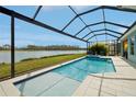 Sparkling screened pool area with seating overlooking a serene lake at 4594 Tour Trce, Land O Lakes, FL 34638