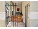 View of the home's front entrance through a black wrought iron gate and steps at 4810 W San Miguel St, Tampa, FL 33629