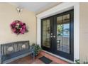 Home's front porch featuring tile flooring, wreath, bench, and decorative molding around a double door entrance at 4810 W San Miguel St, Tampa, FL 33629