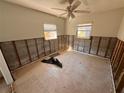 A bedroom that is in need of renovation features tile floors and a ceiling fan at 8361 42Nd N Ave, St Petersburg, FL 33709