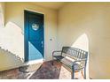 Welcoming front porch with a blue door, a welcome wreath, a bench and brick flooring at 10193 Grand Oak Cir, Madeira Beach, FL 33708