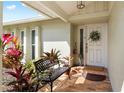 Charming front porch featuring a comfortable bench and colorful plants at 10222 95Th St, Seminole, FL 33777