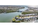 Aerial view of waterfront homes, a canal, bridge, and lush greenery in a coastal community at 330 6Th Ave, Indian Rocks Beach, FL 33785