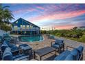 Inviting backyard with a swimming pool, comfortable lounge furniture, and beautiful sunset views at 330 6Th Ave, Indian Rocks Beach, FL 33785