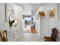 Inviting hallway with tile flooring, coat rack, and views of the water from the living area at 4993 Bacopa S Ln # 304, St Petersburg, FL 33715