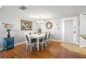 Bright dining room featuring a white table with six chairs, wood floors, and stylish decor at 500 Treasure Island Cswy # 404, Treasure Island, FL 33706