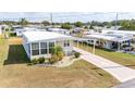 Aerial view of the charming manufactured home with a covered parking area and landscaped yard at 5238 Mary St, Zephyrhills, FL 33542