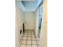 Hallway featuring a washer and dryer hookup and white tiling at 5627 Ashley Oaks Dr # 4, Tampa, FL 33617