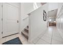 Bright hallway with tile flooring, leading to the main living area with stairs to the second floor at 6256 Shiner St, Land O Lakes, FL 34638