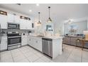 Modern white kitchen with stainless steel appliances and open floor plan concept to living area at 6256 Shiner St, Land O Lakes, FL 34638