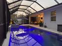 Beautiful pool with lighting in screened-in enclosure. Fire pit and outdoor seating at 817 Wilkie St, Dunedin, FL 34698